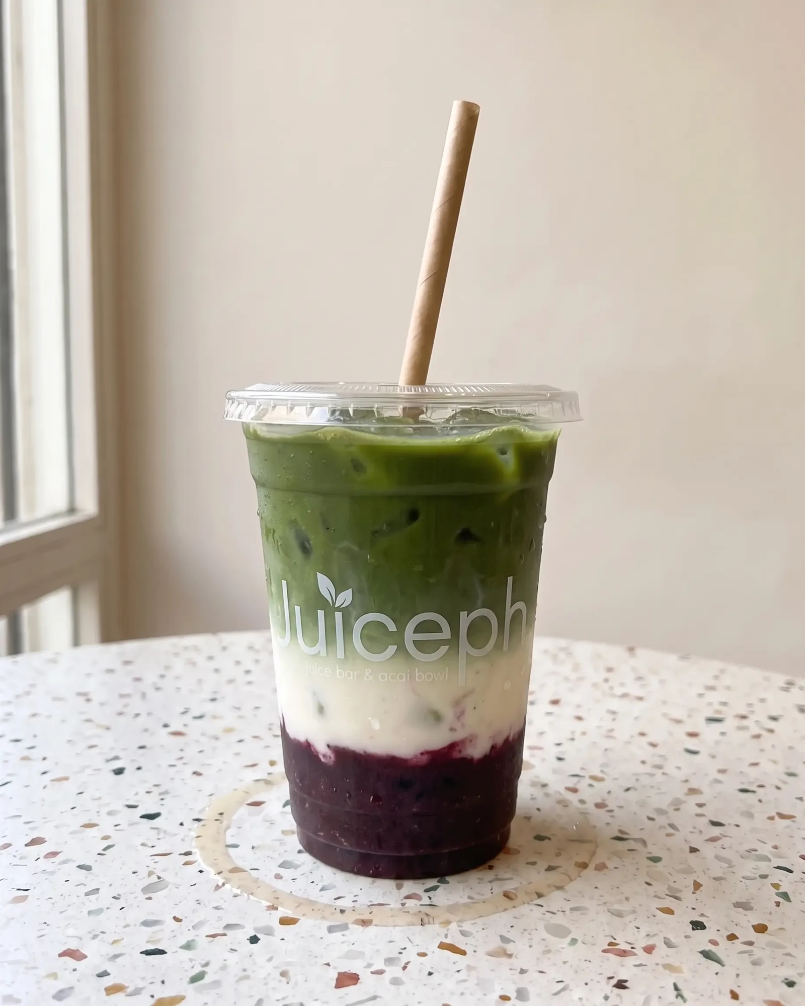 מאצ׳ה אוכמניות של JUICEPH: מאצ׳ה ירוקה מעל חלב ופירה אוכמניות בכוס שקופה