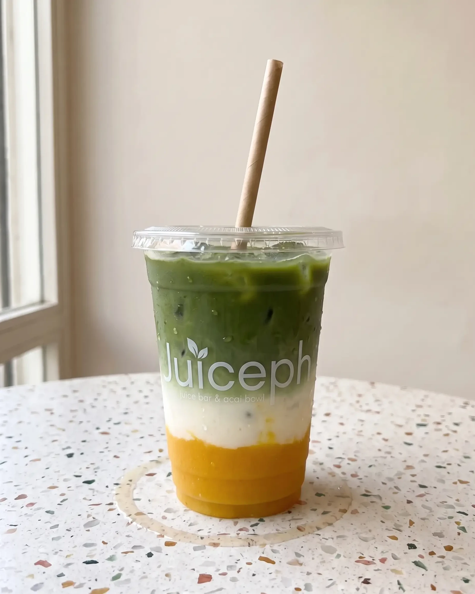 מאצ׳ה מנגו של JUICEPH: מאצ׳ה ירוקה מעל חלב ופירה מנגו בכוס שקופה