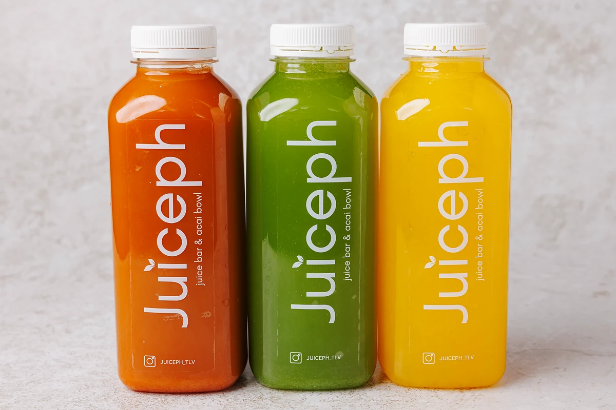שלושה מיצים סחוטים טריים של JUICEPH: כתום, ירוק וצהוב